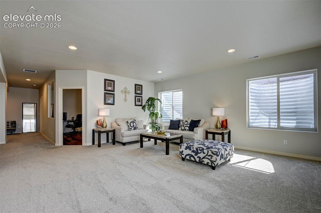 Image 35 of 45: Spacious interior room featuring light-colored carpeting, recessed lighting
