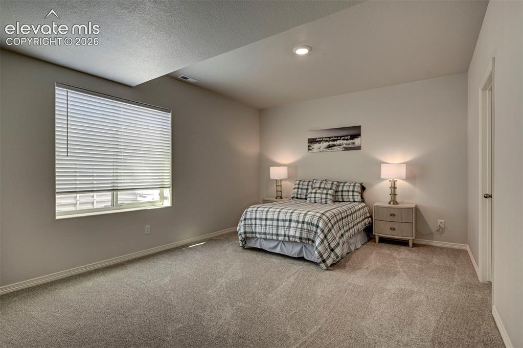 Image 37 of 45: Spacious room featuring neutral carpeting, recessed ceiling lighting, a lar