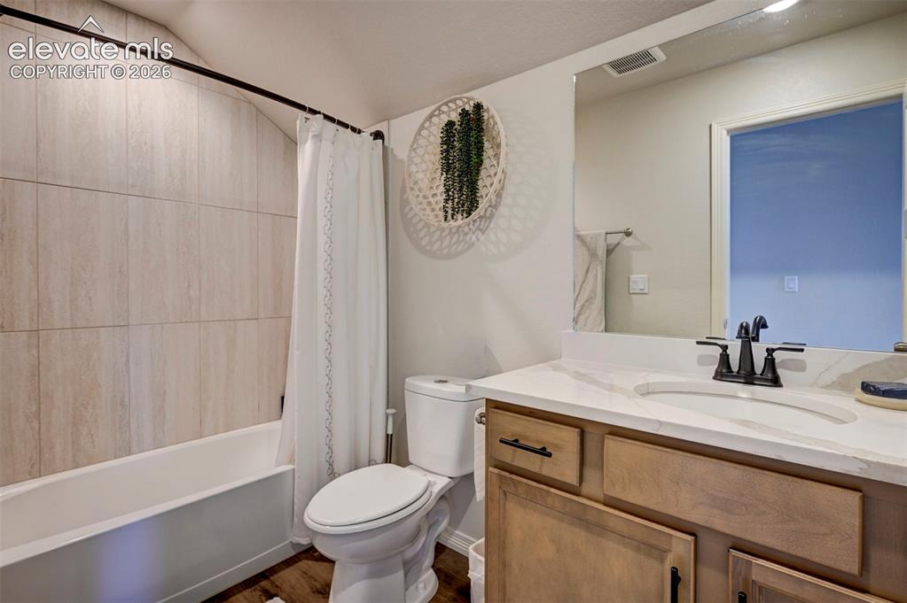 Image 40 of 45: Full bathroom featuring a single vanity with stone countertop, undermount s