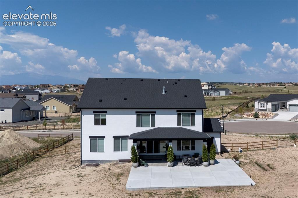 Image 43 of 45: Modern three-story residence featuring a dark shingle roof and white exteri