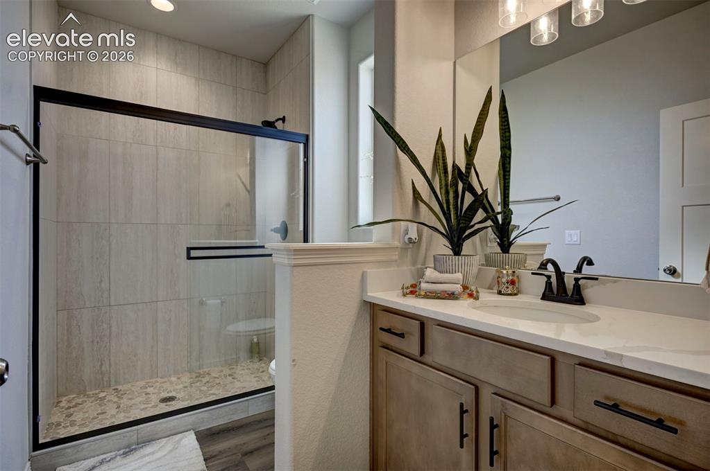 Image 8 of 45: Contemporary bathroom featuring a walk-in shower with vertical tile and peb