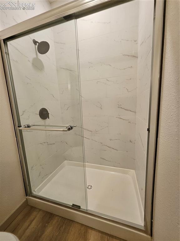 Image 12 of 23: Bathroom with wood finished floors and a stall shower