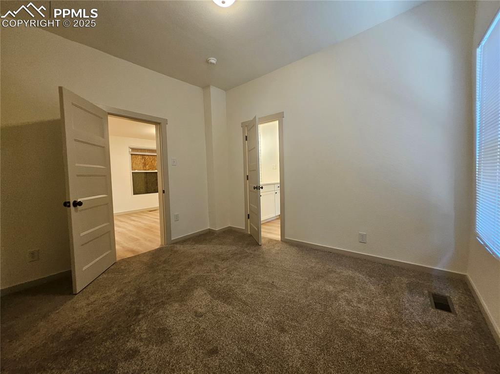 Image 14 of 23: Unfurnished bedroom with carpet and ensuite bathroom