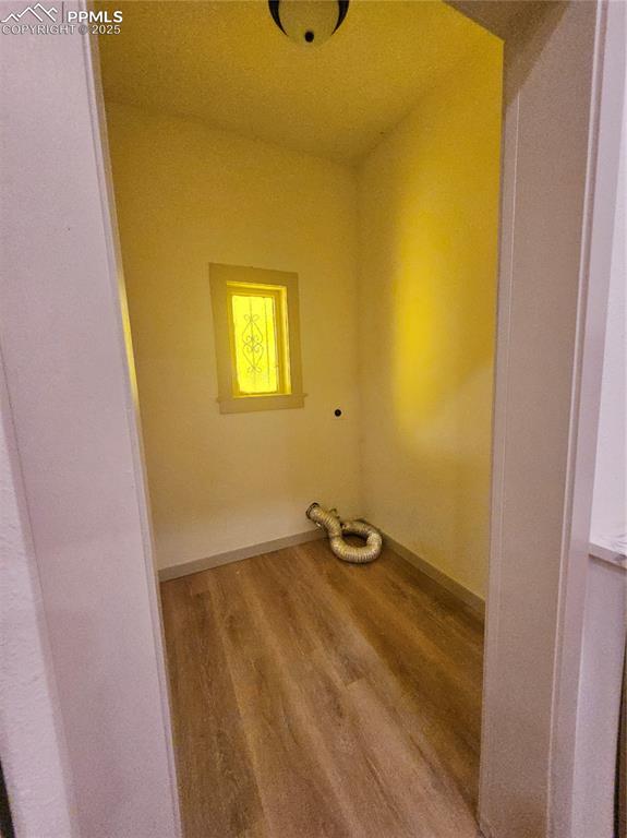 Image 19 of 23: Washroom with wood finished floors and hookup for an electric dryer