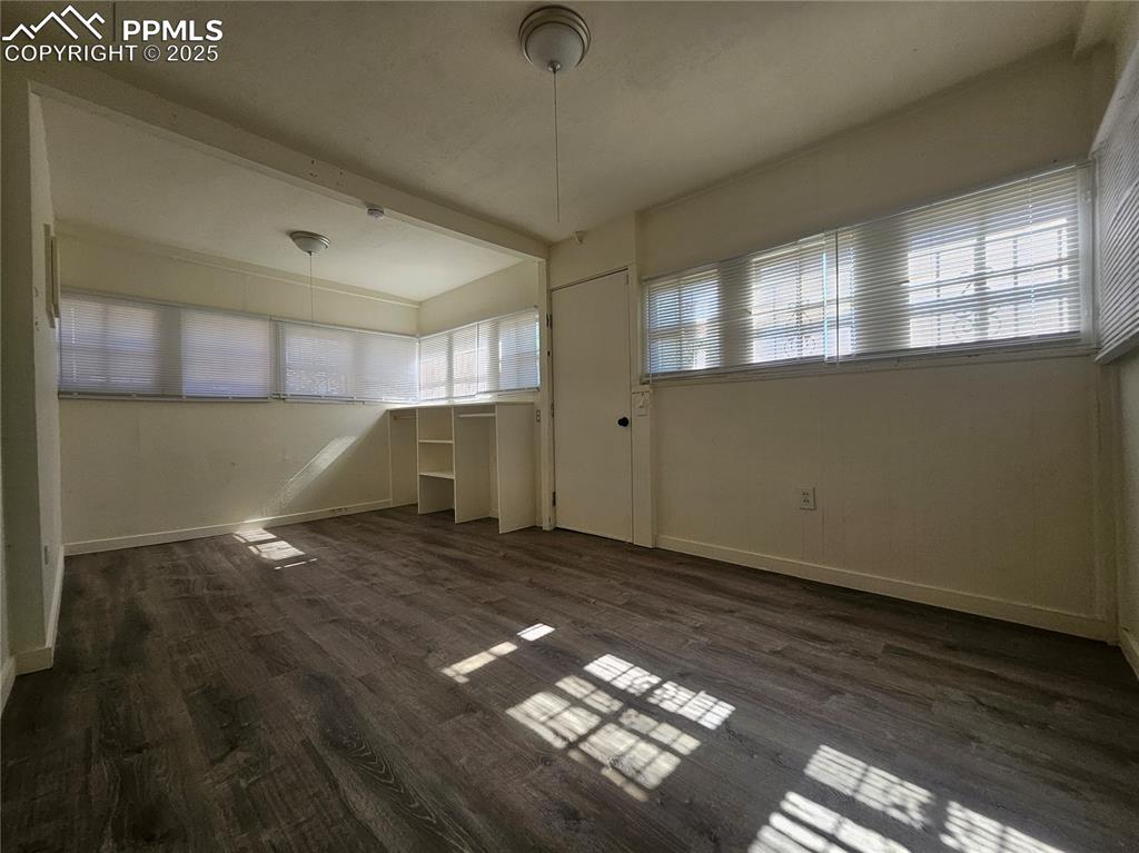 Image 21 of 23: Unfurnished dining area with lofted ceiling and dark wood-type flooring