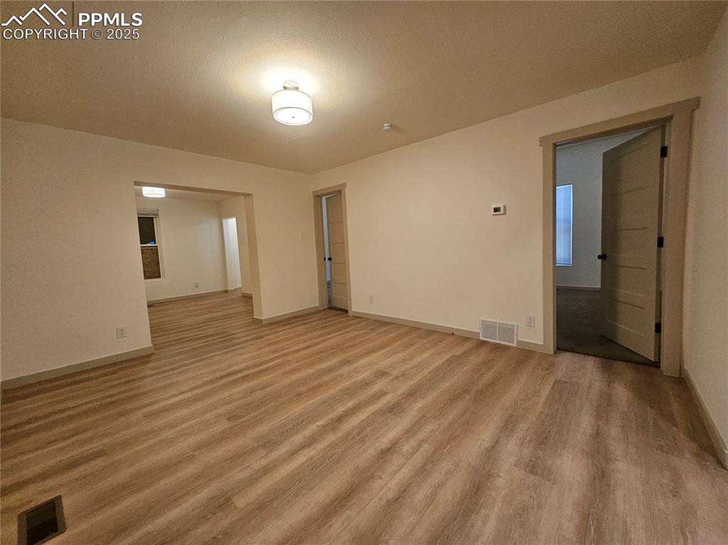 Image 7 of 23: Empty room with light wood finished floors and baseboards