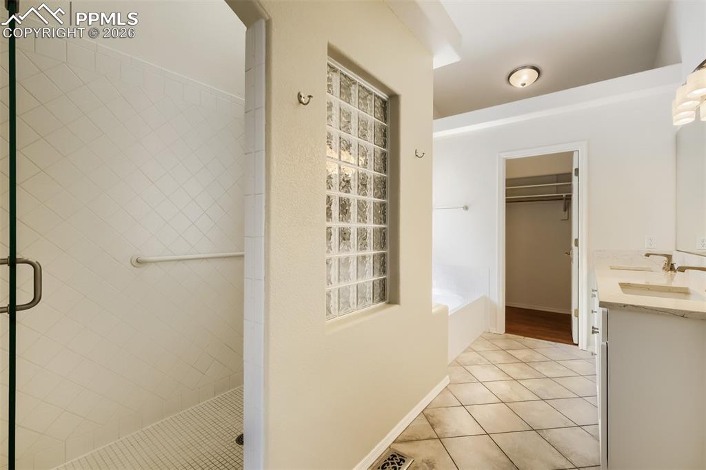 Image 15 of 31: The main level primary suite features vaulted ceilings, engineered wood flo