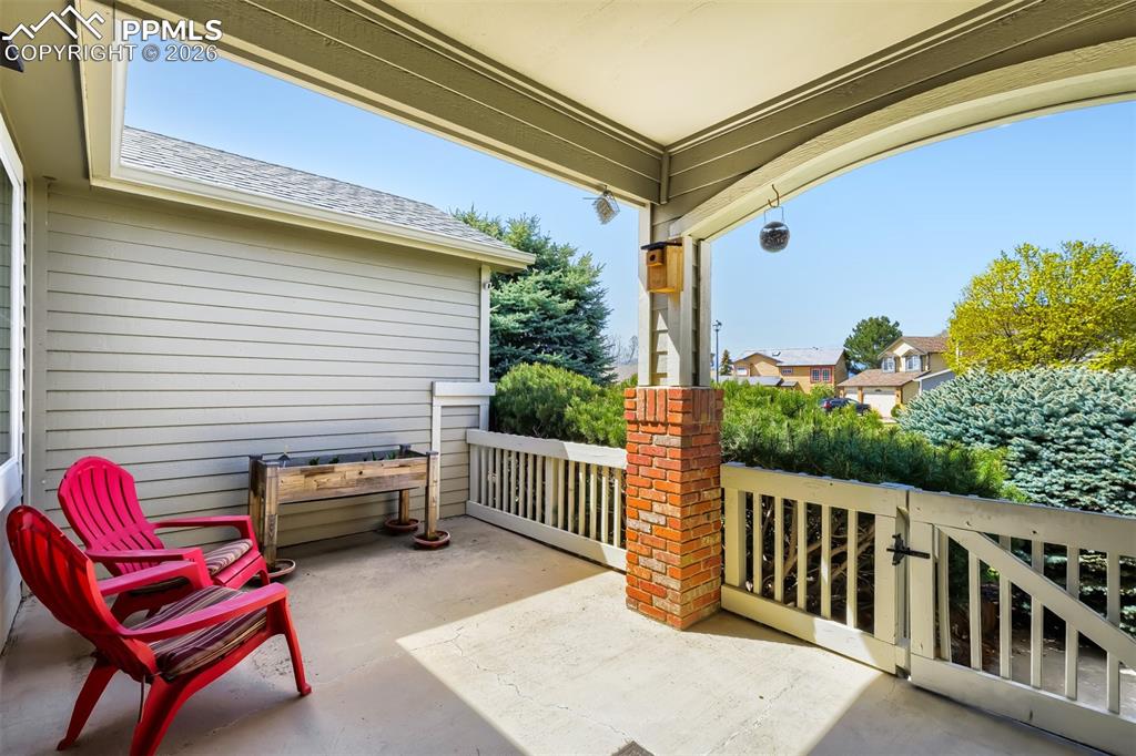 Image 30 of 31: Fenced backyard with a covered patio and mature landscaping 