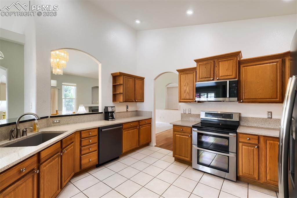 Image 6 of 31: Entry way with vaulted great room features wainscoting and oak hardwood flo
