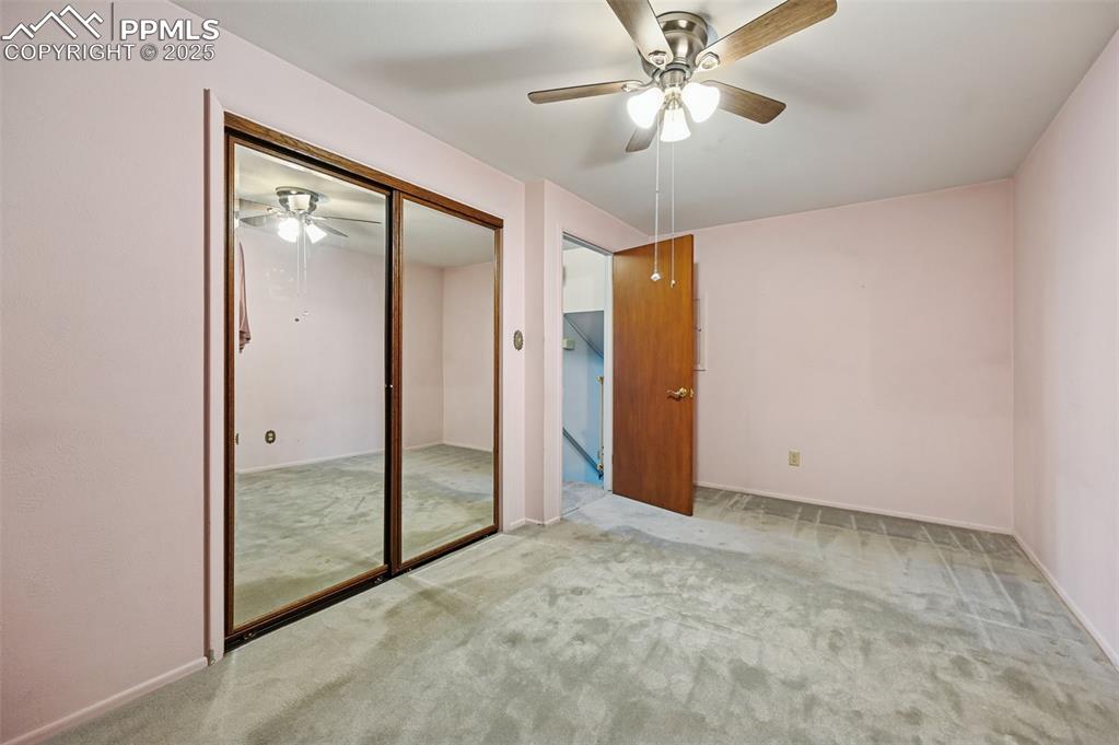 Image 11 of 23: Unfurnished bedroom with carpet flooring, a closet, and ceiling fan