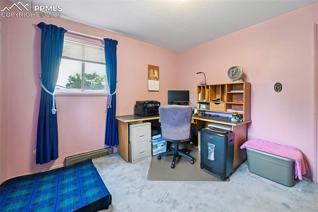 Image 13 of 23: Home office featuring light colored carpet and a baseboard radiator
