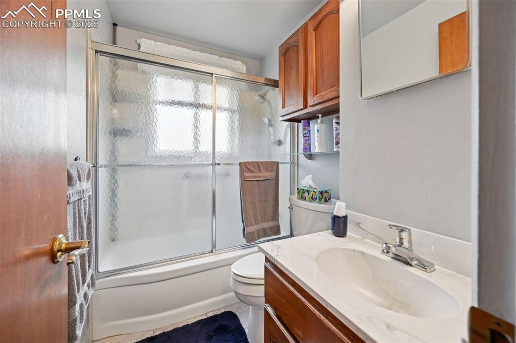 Image 17 of 23: Full bath featuring bath / shower combo with glass door and vanity