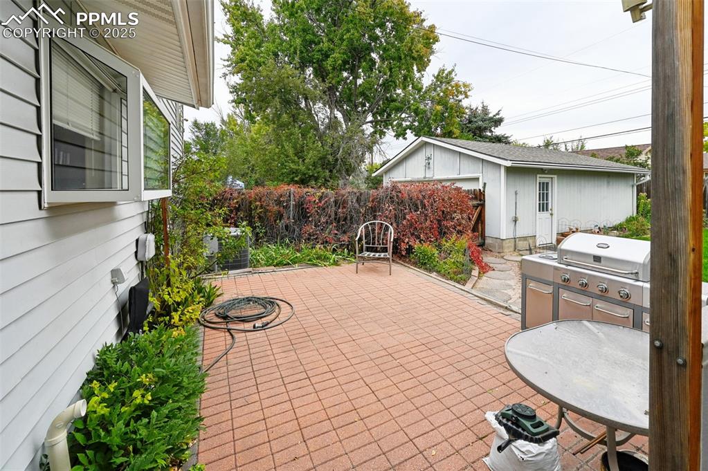 Image 22 of 23: View of patio / terrace featuring an outdoor structure and area for grillin