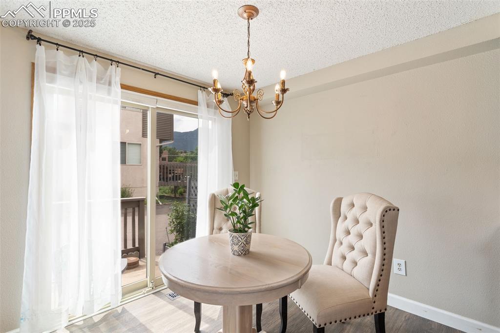 Image 12 of 34: Dining area featuring a chandelier, and walk to side deck.