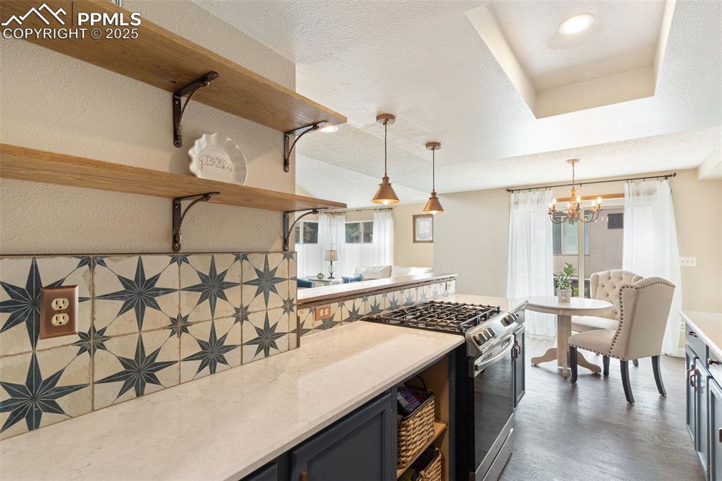 Image 16 of 34: Kitchen with stainless steel range with gas cooktop, a textured ceiling, op
