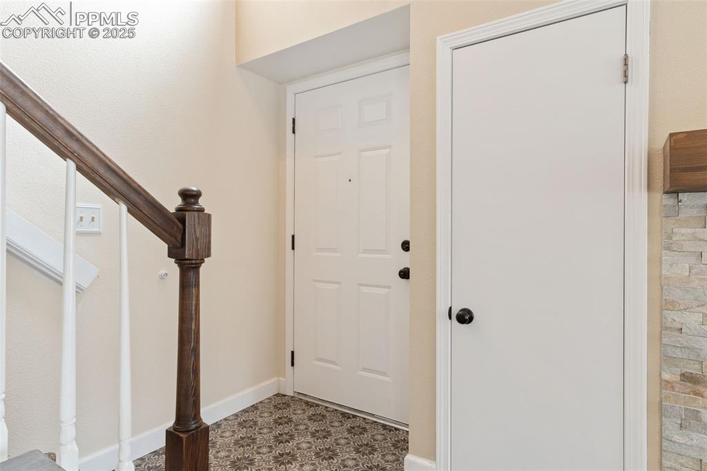 Image 19 of 34: Entrance foyer with stairway and tile patterned floors