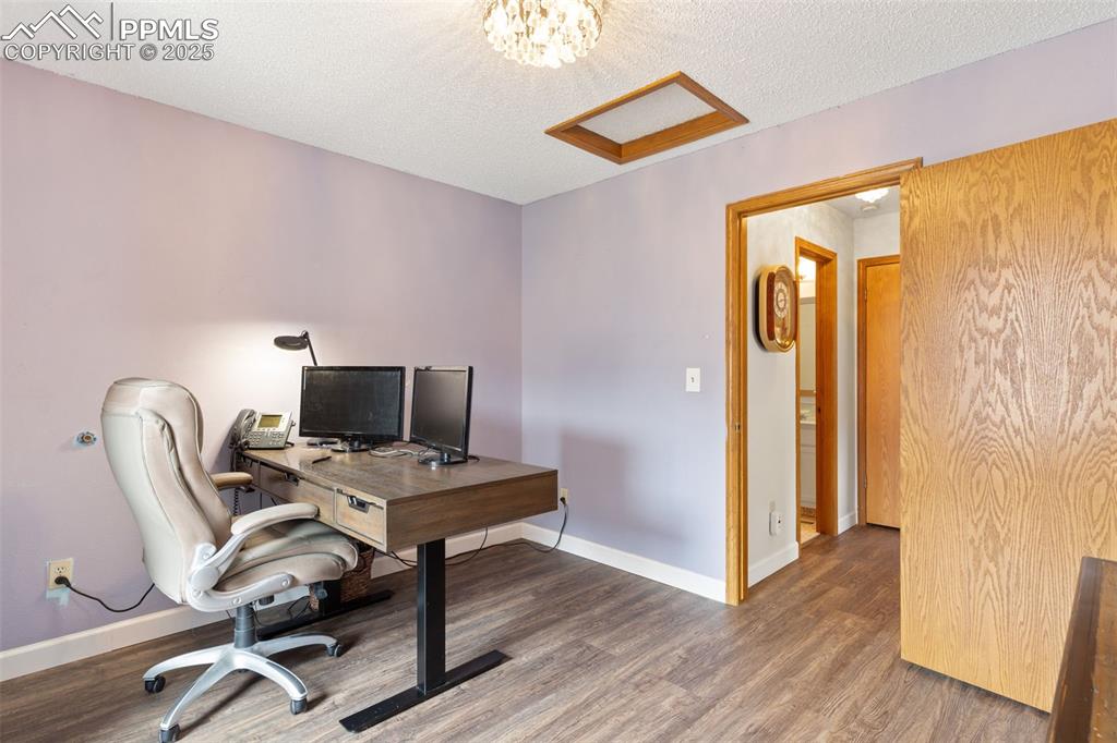 Image 24 of 34: Office featuring a textured ceiling and wood finished floors