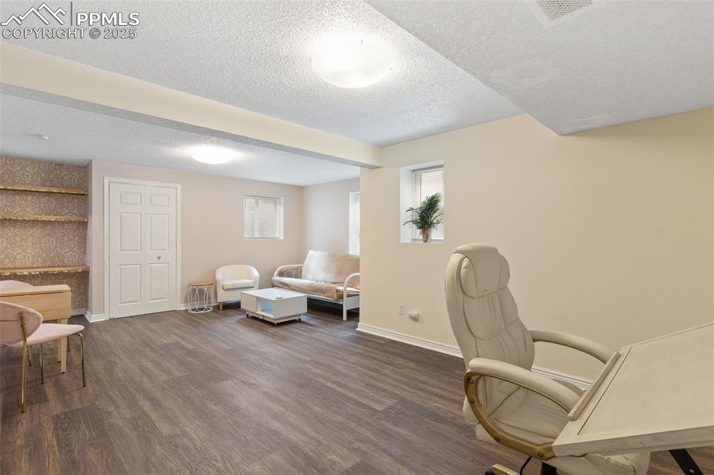Image 26 of 34: Office area with dark wood-style floors and a textured ceiling