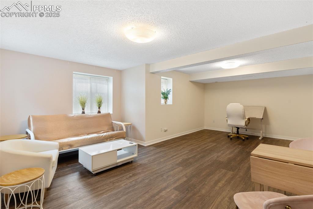 Image 27 of 34: Living room featuring dark wood finished floors and a textured ceiling