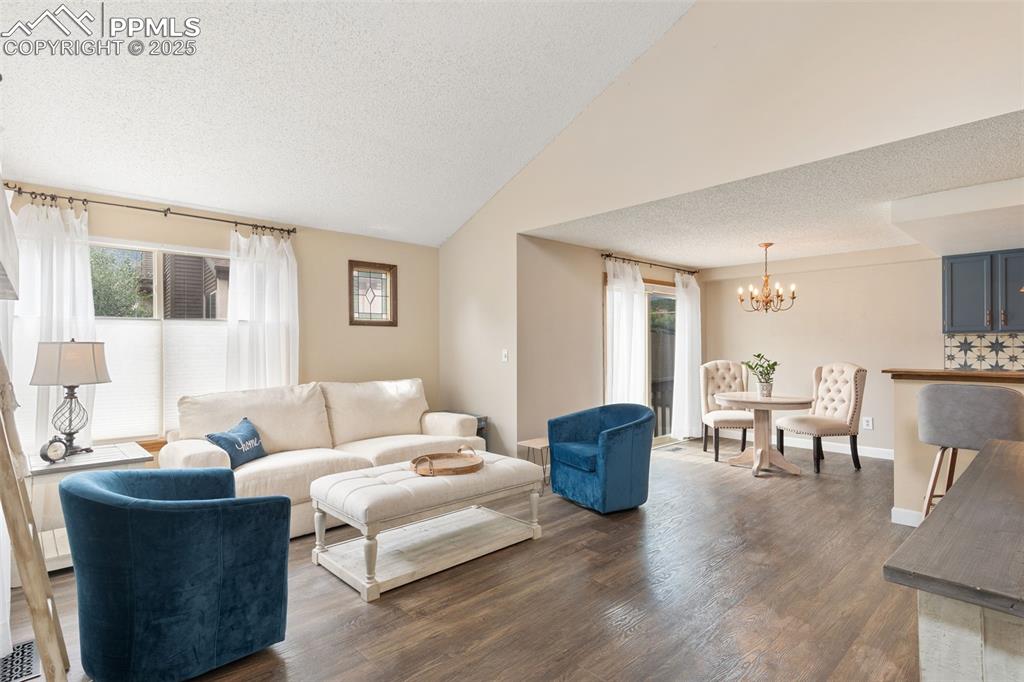 Image 3 of 34: Dark Luxuy Vinyl floors, and lofted ceiling