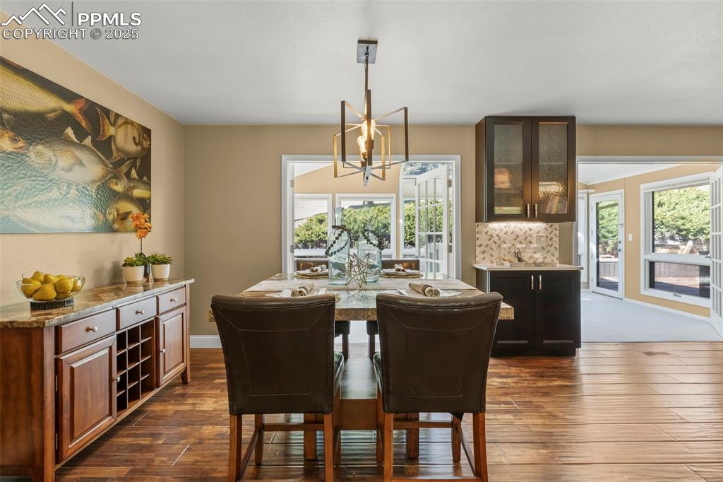 Image 11 of 46: Dining space with a chandelier and dark wood-type flooring
