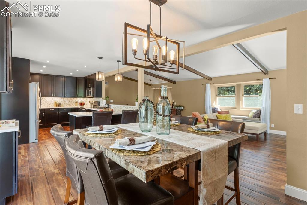 Image 12 of 46: Dining area featuring dark wood-style flooring and a chandelier