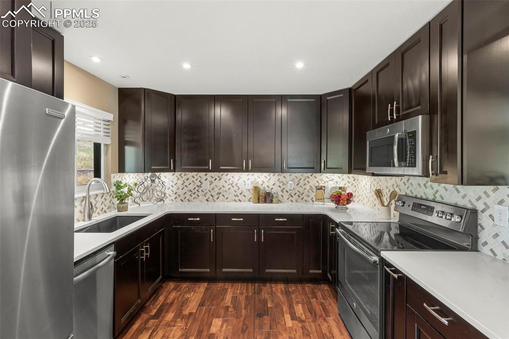 Image 15 of 46: Kitchen featuring stainless steel appliances, dark wood finished floors, da