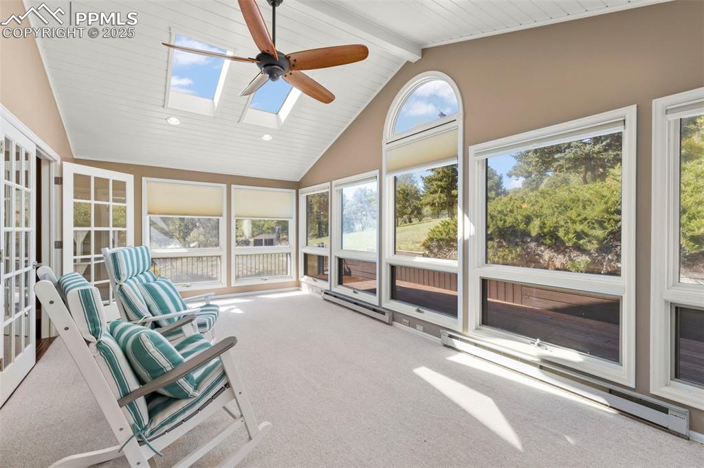 Image 18 of 46: Unfurnished sunroom with a baseboard heating unit, beamed ceiling, a skylig