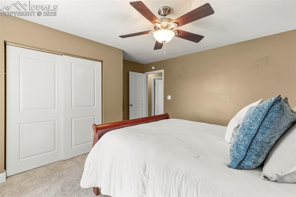 Image 22 of 46: Bedroom with light carpet, ceiling fan, and a closet