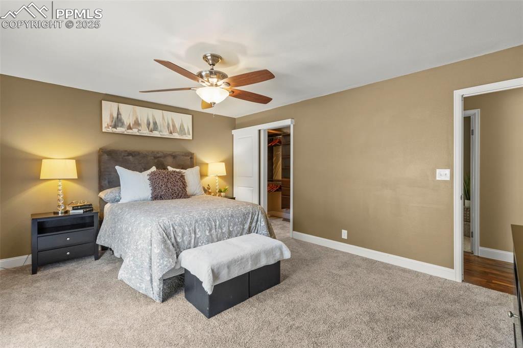 Image 25 of 46: Carpeted bedroom with a walk in closet and a ceiling fan