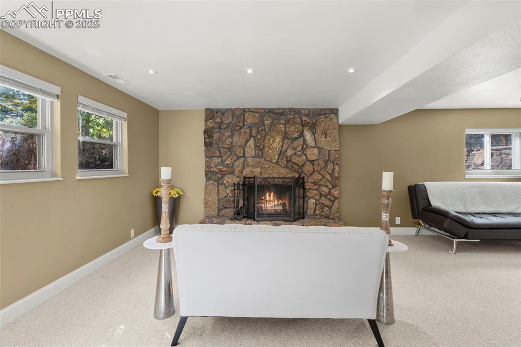 Image 30 of 46: Carpeted living area with a fireplace and recessed lighting
