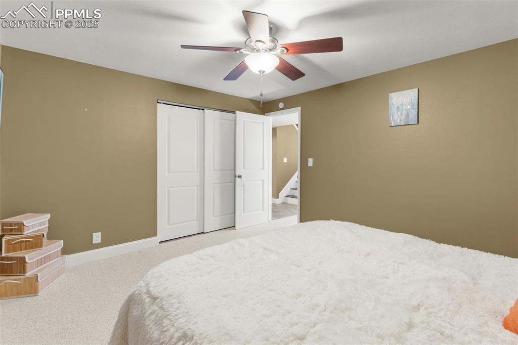 Image 34 of 46: Bedroom with light carpet, ceiling fan, and a closet