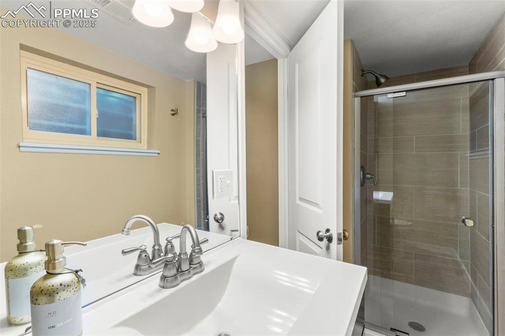 Image 35 of 46: Bathroom with a shower stall and vanity