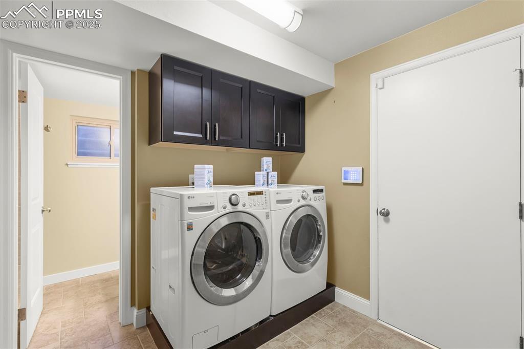 Image 36 of 46: Laundry room featuring cabinet space, washer and dryer, and light tile patt