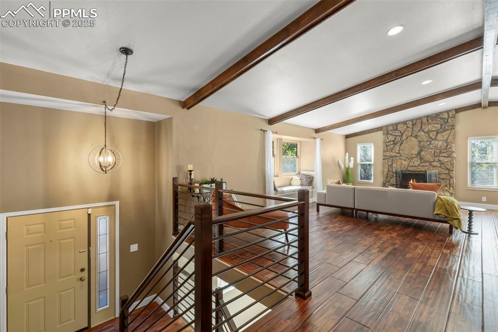 Image 6 of 46: Foyer entrance featuring dark wood-type flooring, a fireplace, a chandelier