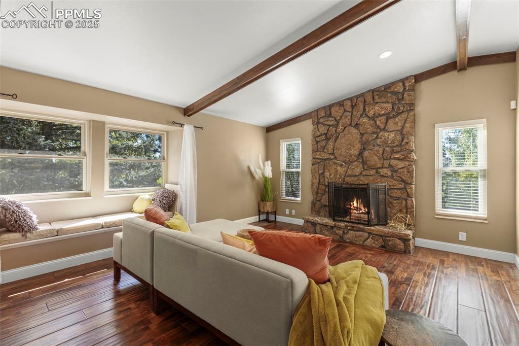 Image 7 of 46: Living area featuring a stone fireplace and hardwood / wood-style floors
