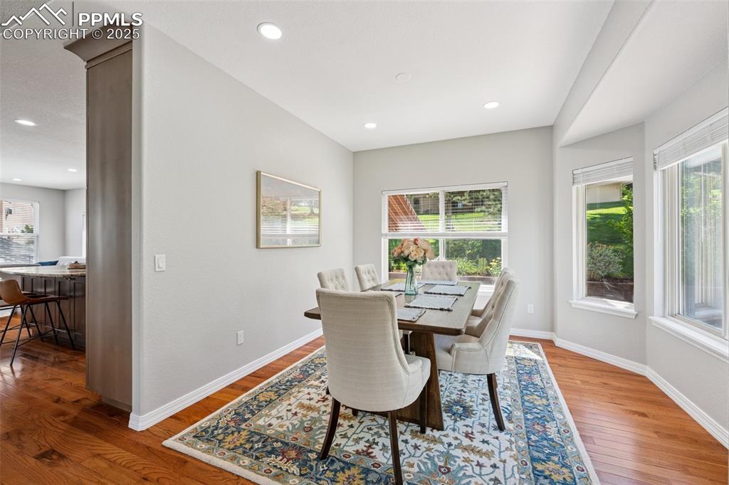 Image 19 of 50: Dining area with wood finished floors and recessed lighting