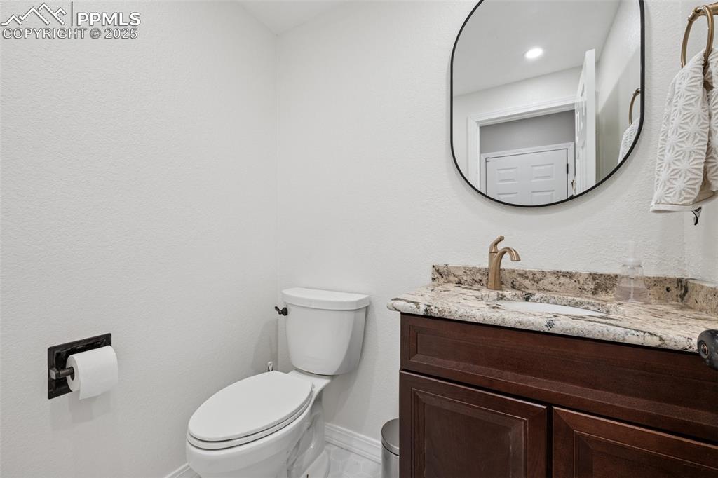 Image 21 of 50: Half bath with baseboards and vanity