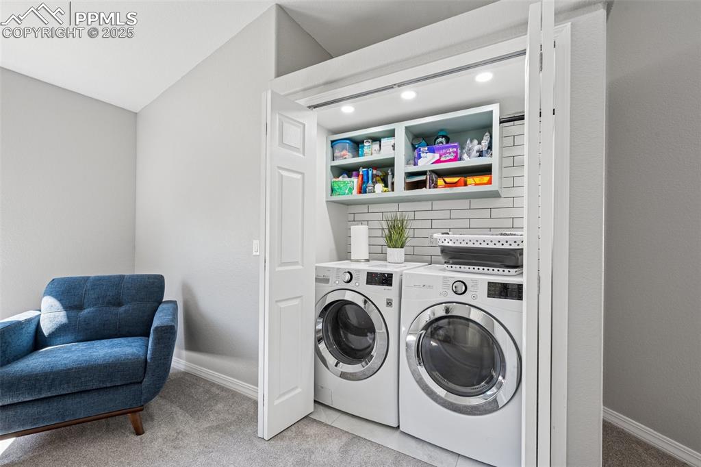 Image 24 of 50: Laundry room with washer and dryer and light carpet