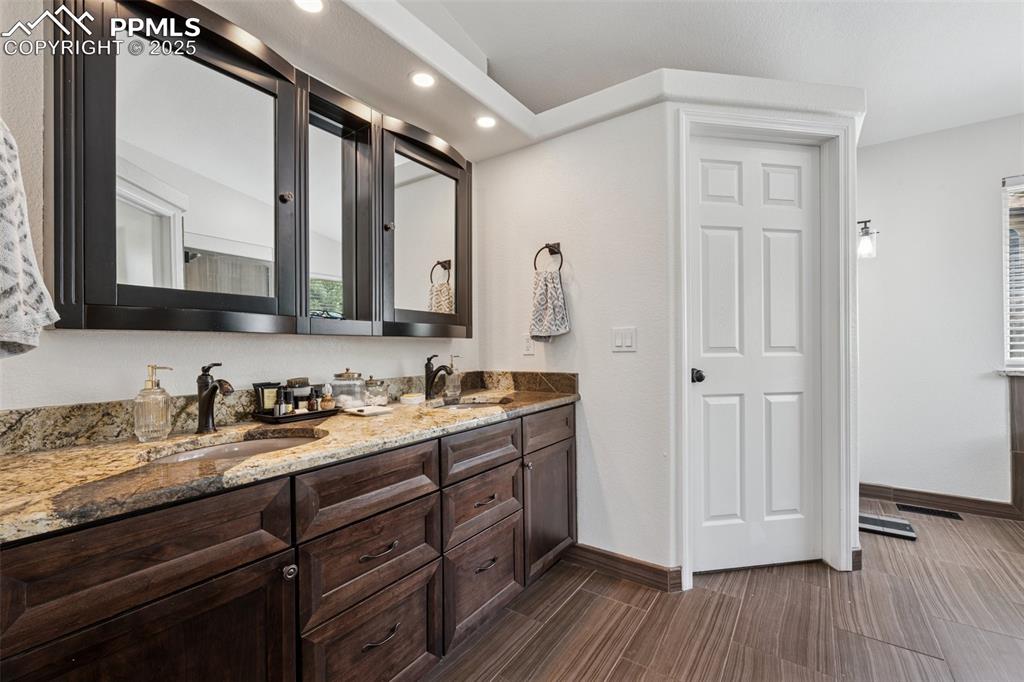 Image 28 of 50: Bathroom with double vanity and recessed lighting