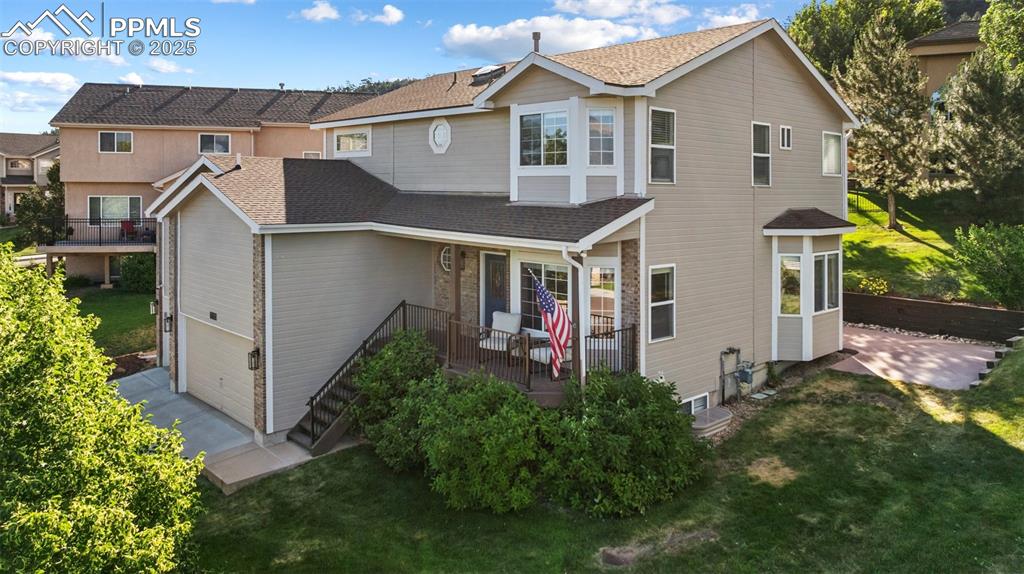 Image 3 of 50: View of front of home featuring a front lawn, a shingled roof, a garage, an