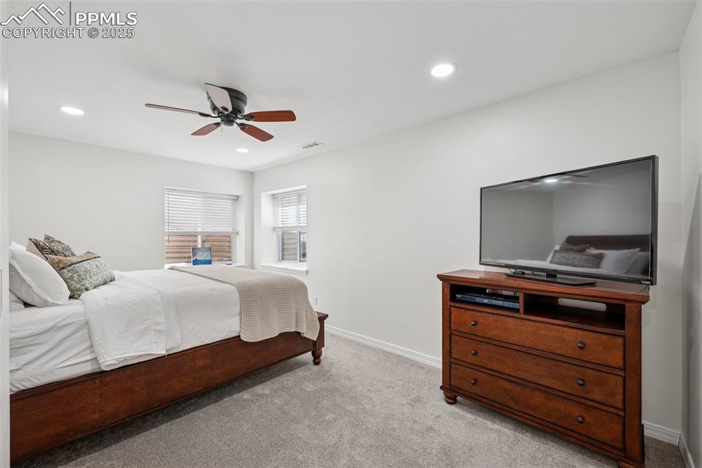 Image 40 of 50: Carpeted bedroom with recessed lighting and a ceiling fan