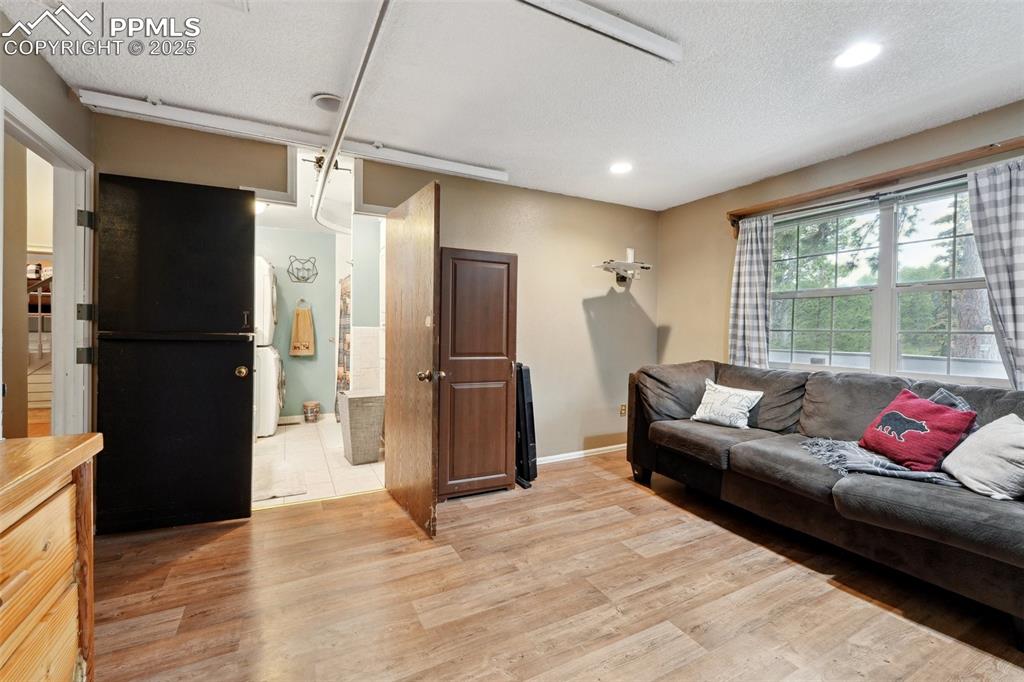 Image 16 of 38: Living room with light wood-style flooring, baseboards, recessed lighting, 