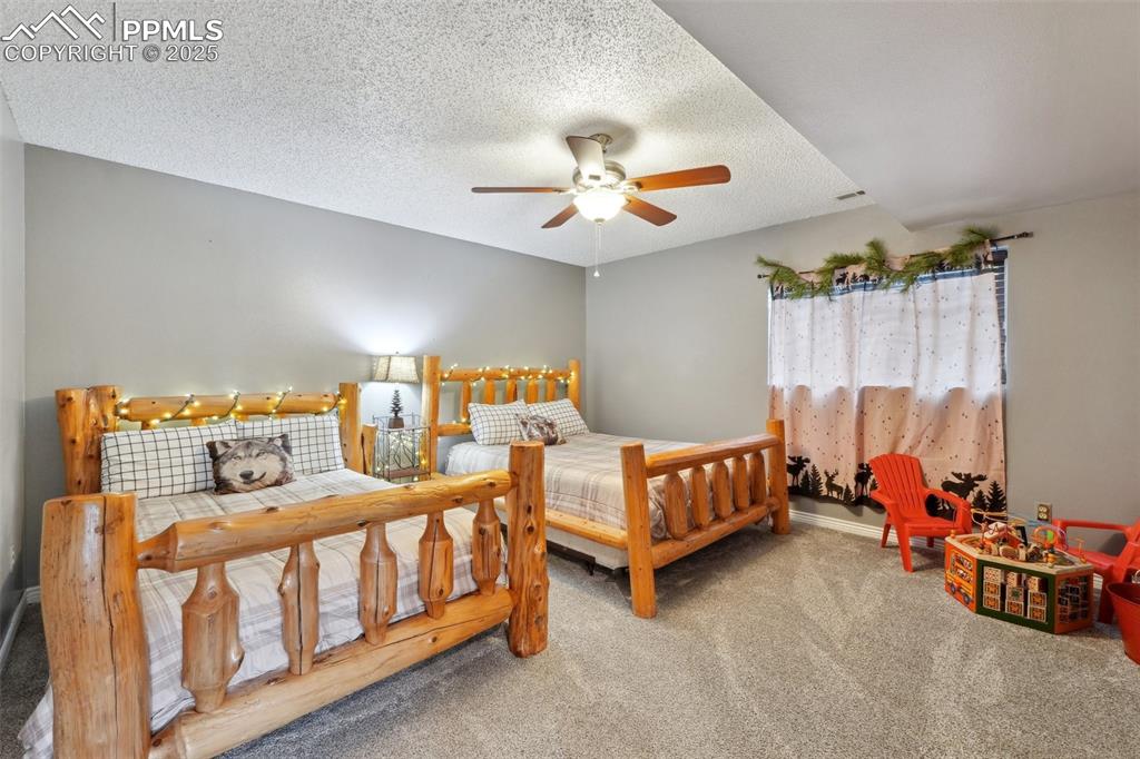 Image 19 of 38: Carpeted bedroom featuring a textured ceiling and ceiling fan