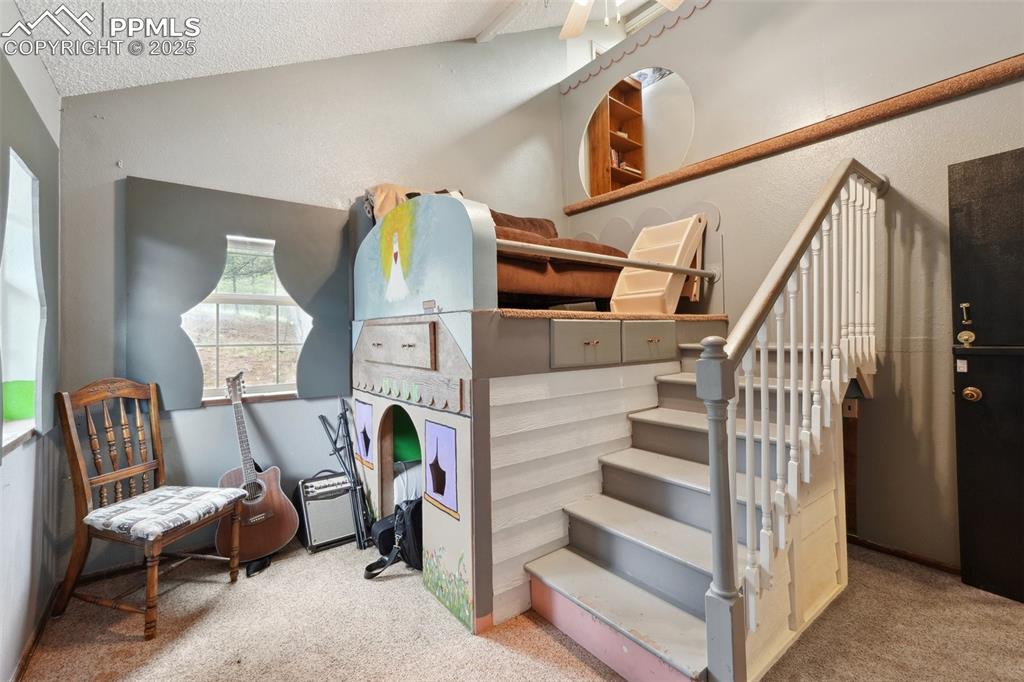 Image 22 of 38: Stairs featuring carpet, a textured ceiling, and lofted ceiling