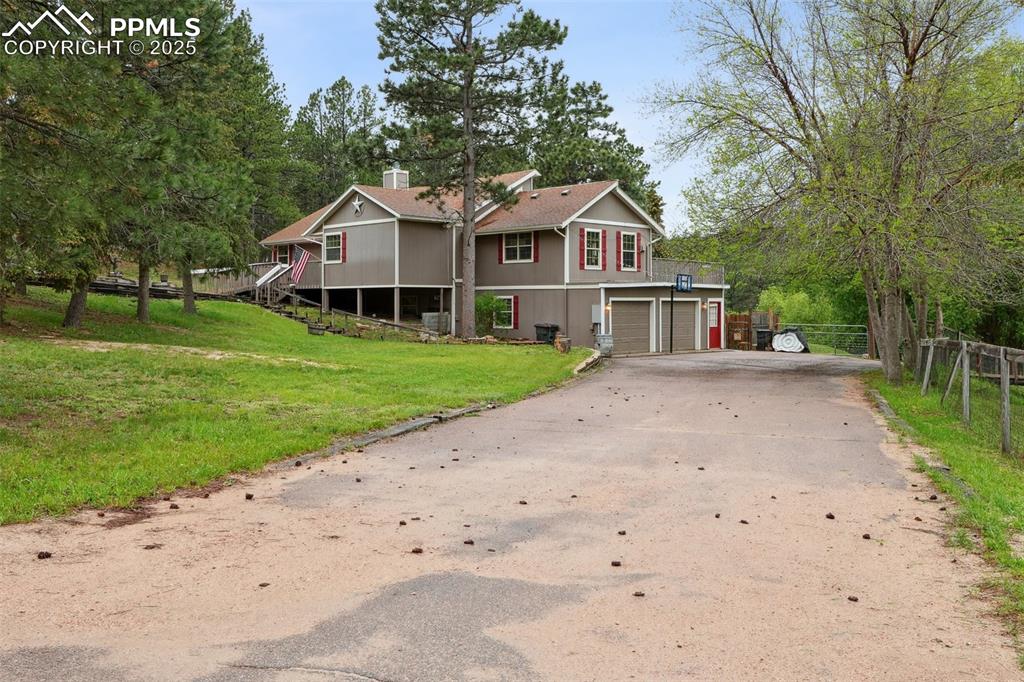 Image 33 of 38: View of front of house featuring driveway, a garage, and a chimney