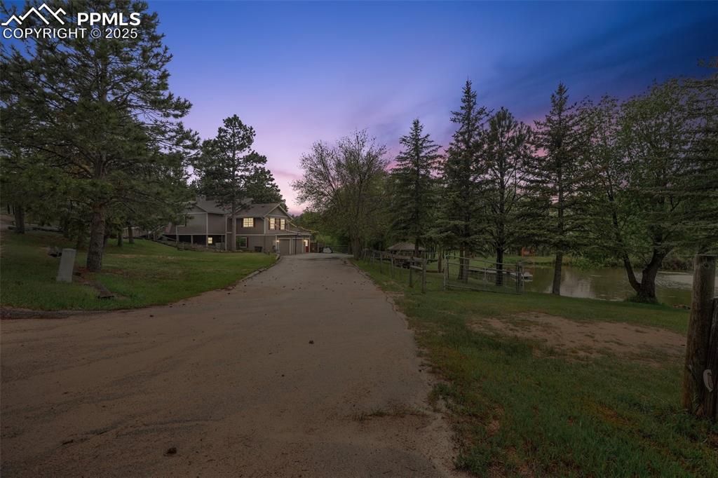 Image 36 of 38: View of dirt / gravel driveway featuring a water view