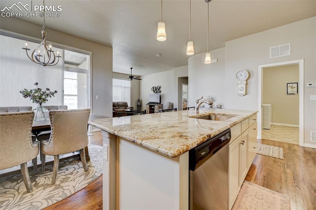 Image 4 of 31: Kitchen with light wood-type flooring, stainless steel dishwasher, a sink,