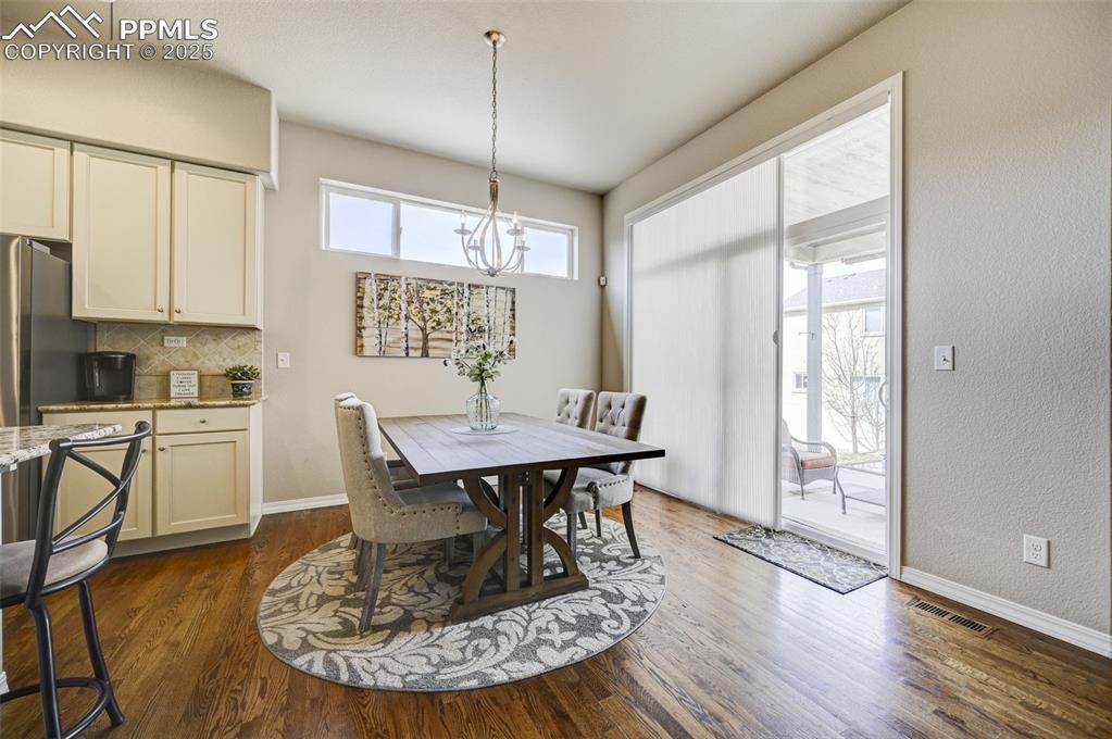 Image 7 of 31: Dining space with visible vents, dark wood-style flooring, and a healthy am