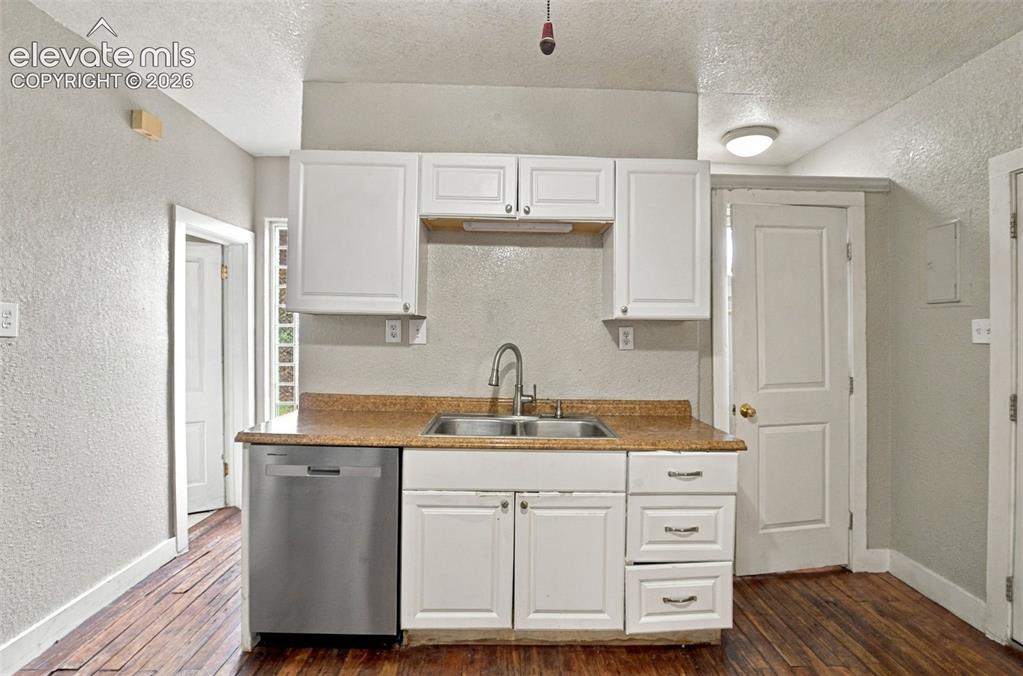 Image 11 of 34: Kitchen featuring white cabinetry, a stainless steel dishwasher, a double b